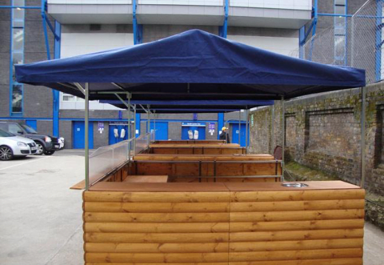 Big kahuna wooden hut with dark blue roof in a car park