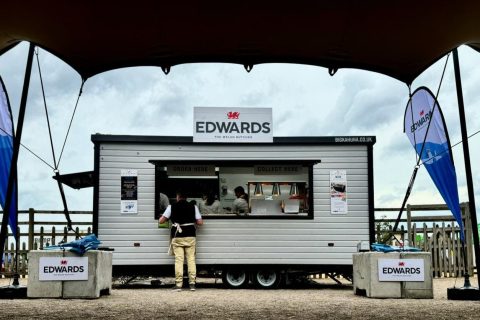 Custom-built food trailer with serving hatch and full wrap branding at outdoor event