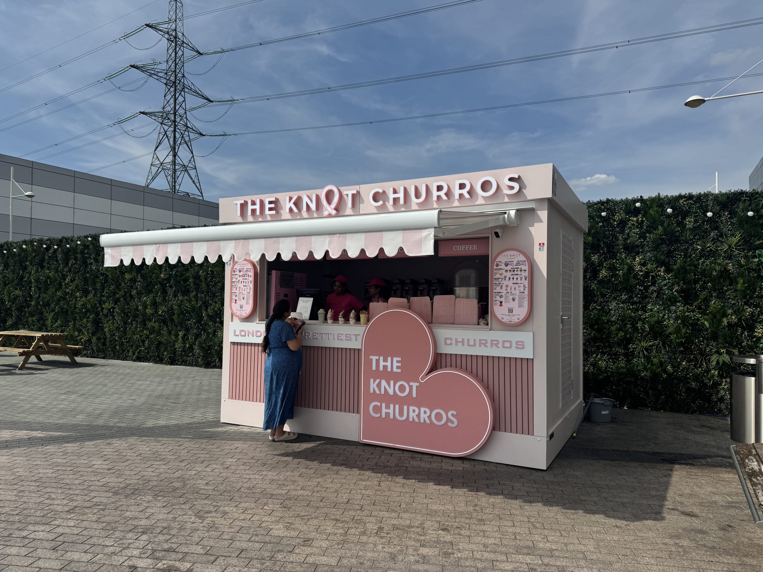 Mobile catering pod with hot cupboard, double sink, and overhead signage for efficient food service.