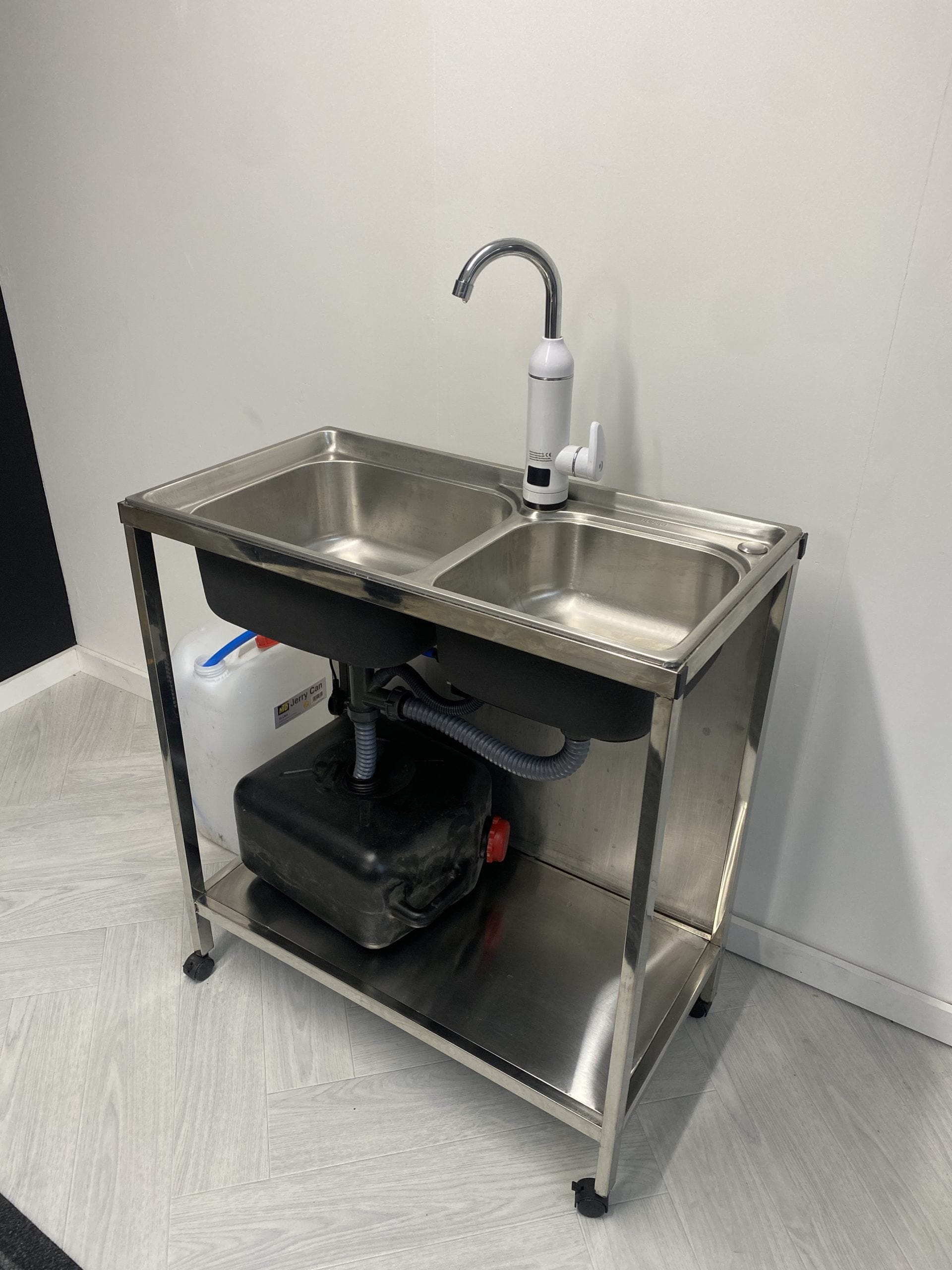 Mobile sink unit with double basins and water heater, ideal for outdoor catering hygiene