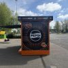 Side view of modular brand activation kiosk with full campaign graphics